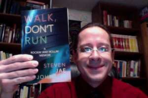 Publisher Tony Michalski proudly displays Steven Jae Johnson's incredible and exciting book "Walk, Don't Run: A Rockin' and Rollin' Memoir."